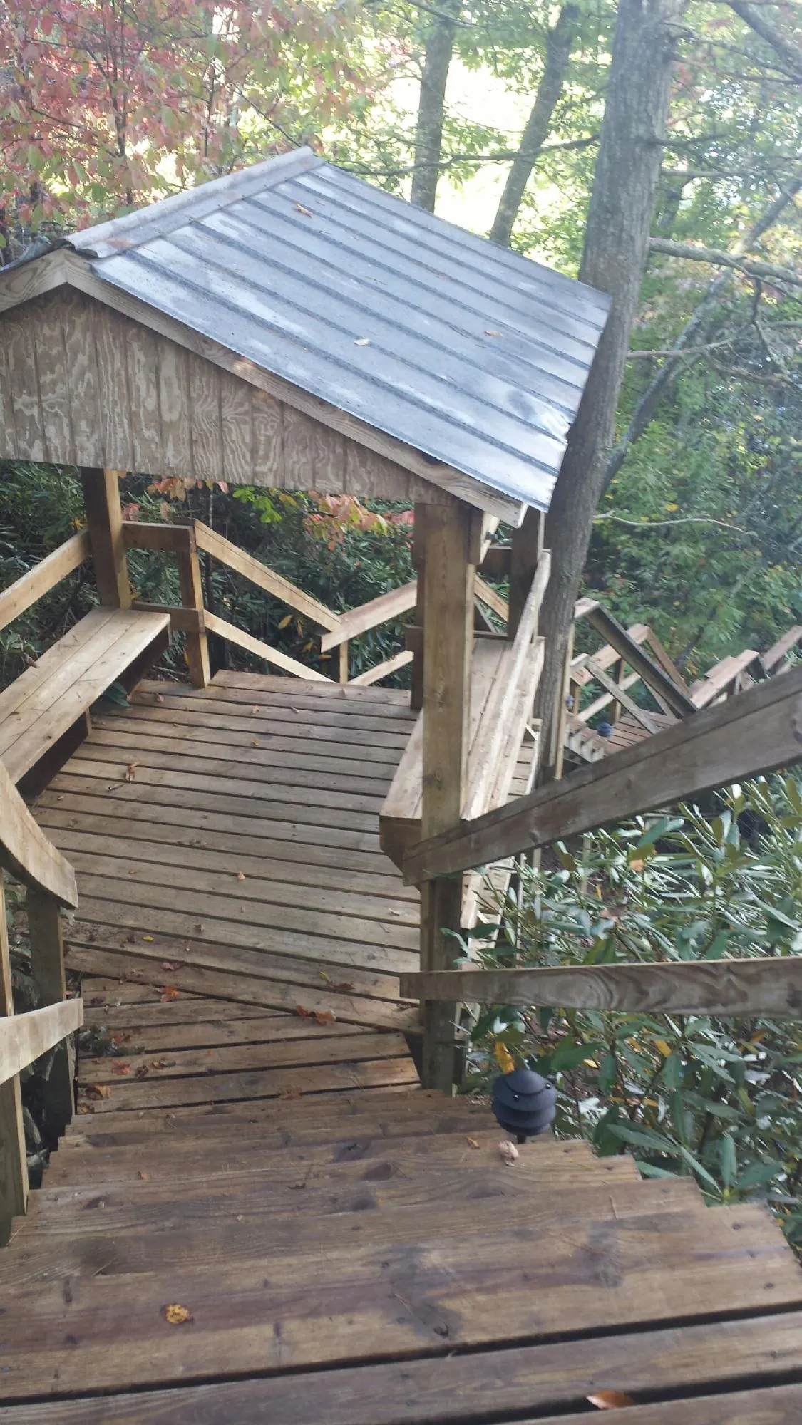 Metal roofed shelter over wooden steps on a wooded walkway — Skylight Repair & Installation work by our crew in Cropseyville