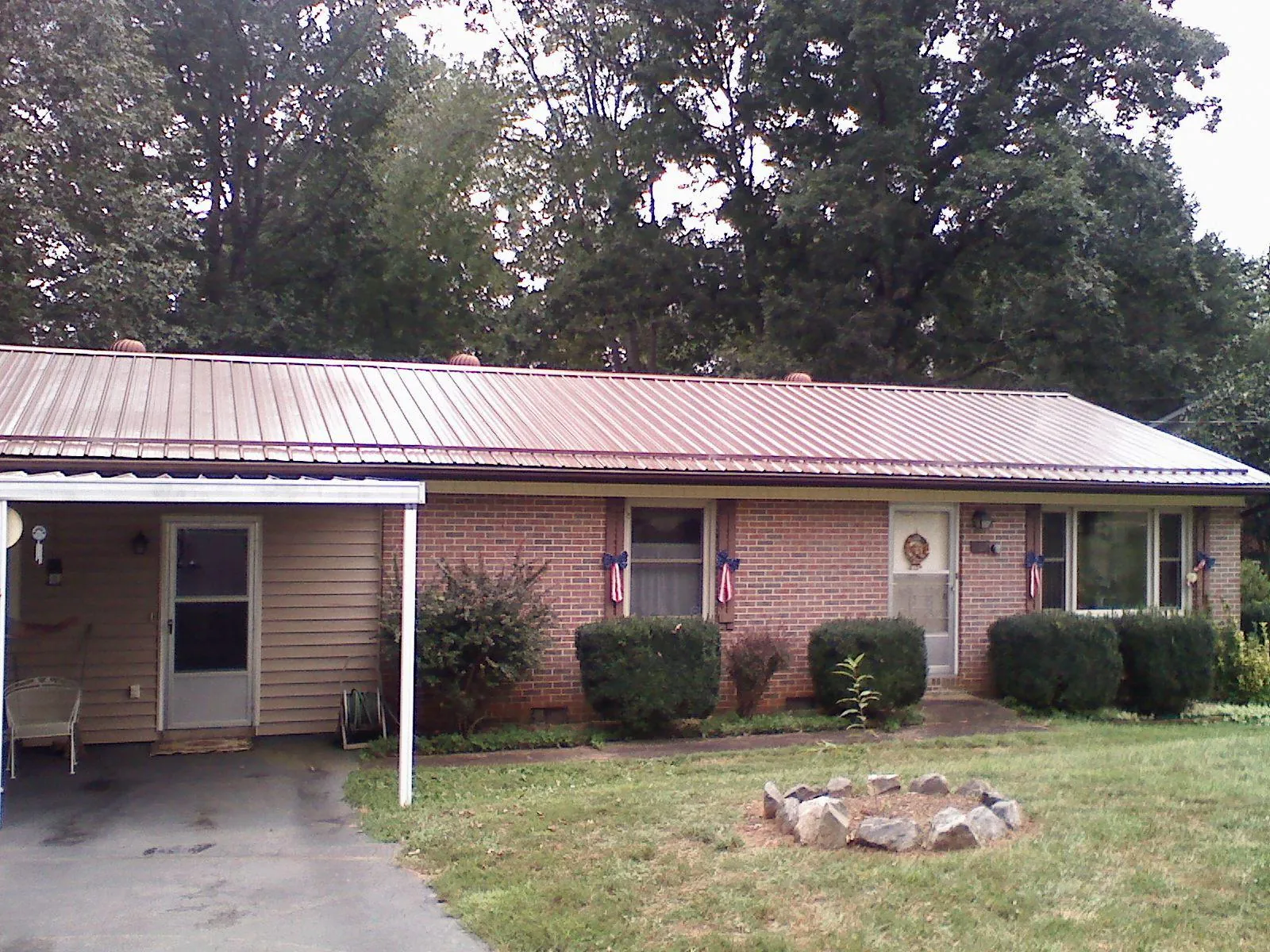 Bronze metal roof and carport on a brick ranch home — Roof Repair work by our crew in Cropseyville
